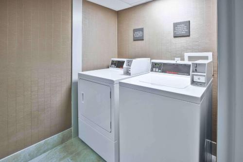 莫米南托莱多莫米希尔顿恒庭酒店的洗衣房配有洗衣机和烘干机