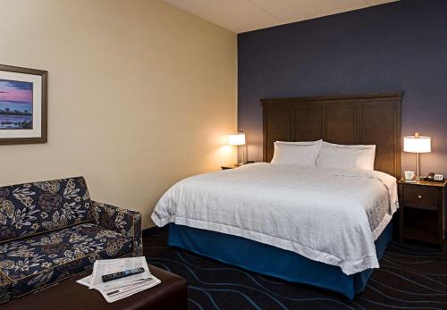 渥太华渥太华机场希尔顿汉普顿酒店的配有一张床和一把椅子的酒店客房