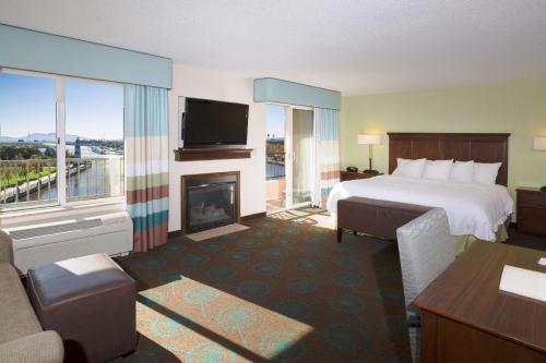 Suisun City萨斯城河岸汉普顿酒店及套房的酒店客房配有一张床和一个壁炉。