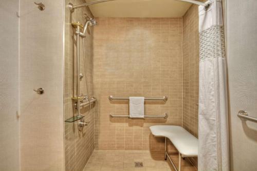 库克维尔库克维尔汉普顿酒店的带淋浴和白色椅子的浴室
