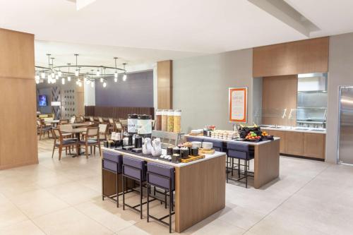 布鲁姆菲尔德Hilton Garden Inn Broomfield Boulder的厨房以及带桌椅的用餐室。