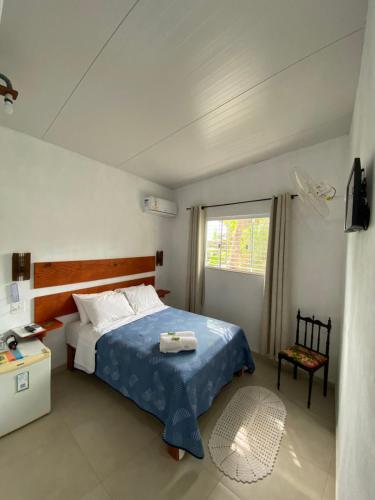 阿拉夏奇巴海滩Casa Caiçara的一间卧室设有蓝色的床和窗户。