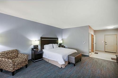 利格城休斯顿/利格城汉普顿套房酒店的配有一张床和一把椅子的酒店客房