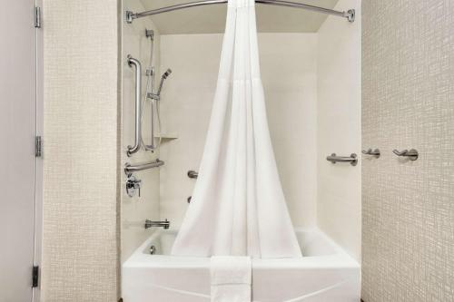 布鲁克菲尔德布鲁克菲尔德希尔顿恒庭酒店的浴室内配有白色淋浴帘。