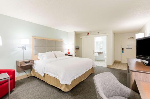 罗切斯特汉普顿罗切斯特酒店的酒店客房设有一张大床和一台电视。