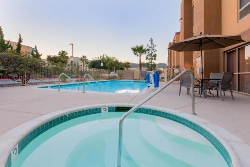 圣马科斯圣马科斯汉普顿酒店的一个带桌子和遮阳伞的游泳池
