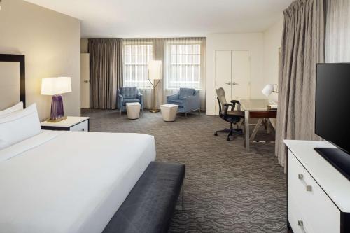 底特律DoubleTree Suites by Hilton Hotel Detroit Downtown - Fort Shelby的酒店客房设有一张大床和一张书桌。