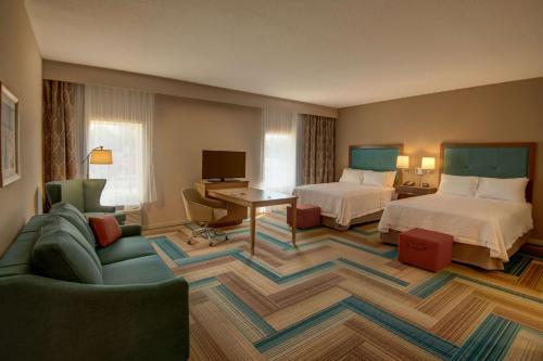 普兰特城Hampton Inn Plant City的酒店客房,设有两张床和一张沙发