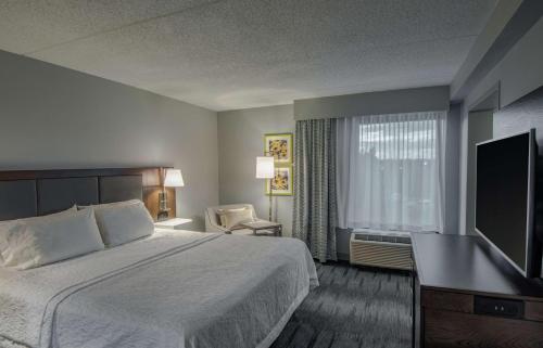 华尔道夫华尔道夫汉普顿酒店的配有一张床和一台平面电视的酒店客房