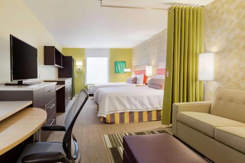 北坎顿坎通希尔顿惠庭酒店的酒店客房设有一间带一张床和一张书桌的卧室