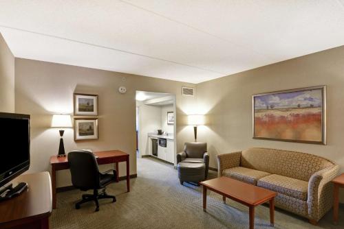 Sayre沙耶尔汉普顿酒店的酒店客房设有沙发、椅子和电视。