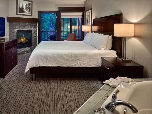 加特林堡盖特林堡希尔顿花园酒店的酒店客房配有一张床和一个壁炉。