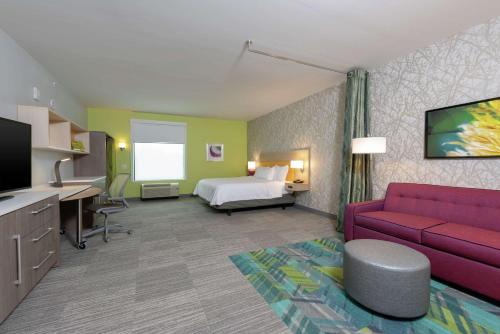 印第安纳波利斯Home2 Suites By Hilton Indianapolis Airport的酒店客房,配有床和沙发
