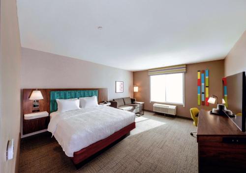 针城Hampton Inn Needles的大型酒店客房,配有一张床和一张书桌