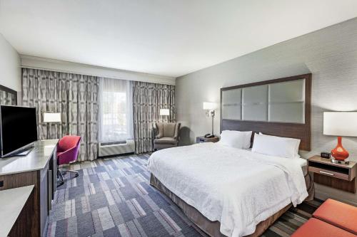 北小石城北小石城麦凯恩商场汉普顿酒店 的配有一张床和一台平面电视的酒店客房
