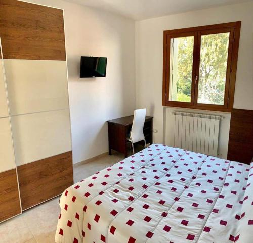 菲夏诺Residenze Salernitane的一间卧室配有一张床、一张书桌和一个窗户。