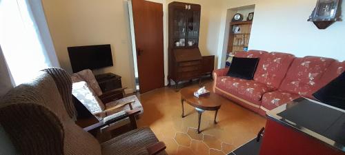 多尼戈尔Biddys cottage的客厅配有红色的沙发和桌子