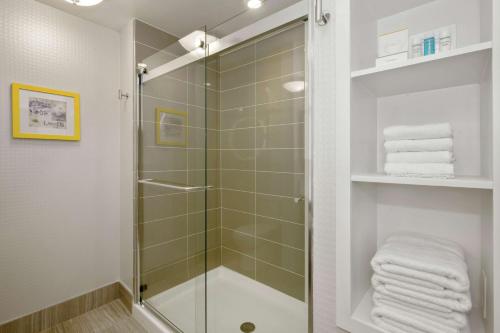 罗利罗利-达勒姆机场/石南溪汉普顿套房酒店的浴室里设有玻璃门淋浴