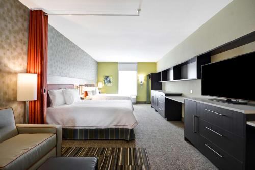汉福德Home2 Suites By Hilton Hanford Lemoore的配有一张床和一台平面电视的酒店客房