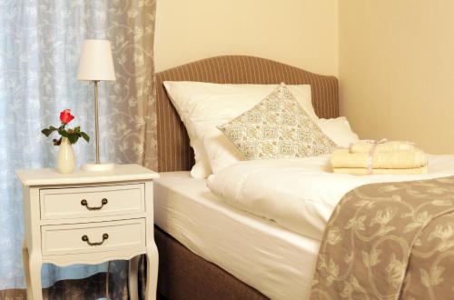 利普施塔特豪斯格美尔旅馆的一间卧室配有一张床,床头柜配有一张白色的床