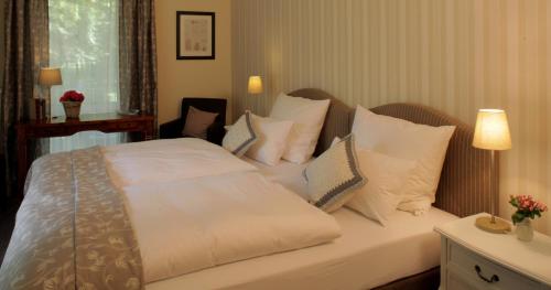 利普施塔特豪斯格美尔旅馆的一间卧室配有带白色床单和枕头的床。