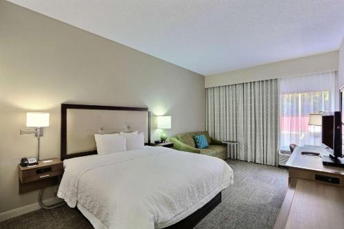 列治文山萨凡纳I-95/里奇满山希尔顿恒庭酒店的酒店客房带一张大床和一把椅子