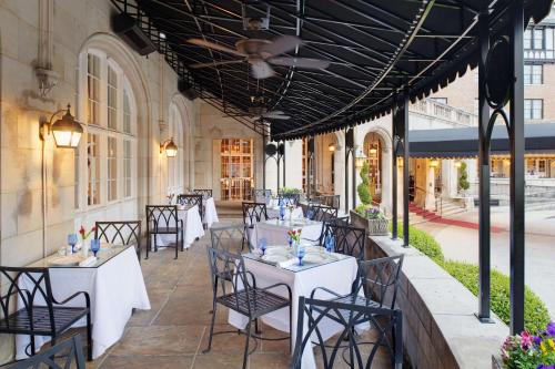 罗阿诺罗阿诺克会议酒店 - 希尔顿Curio Collection酒店的庭院里的餐厅配有白色的桌椅