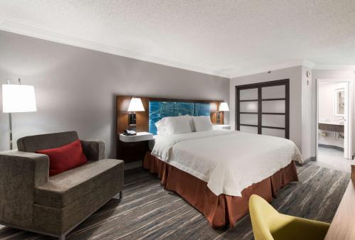霍夫曼庄园芝加哥荷夫曼庄园希尔顿恒庭旅馆&套房酒店的配有一张床和一把椅子的酒店客房