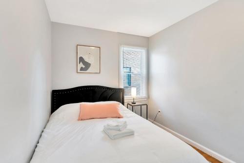 底特律Comfortable Family Residence near Downtown Detroit的白色卧室配有一张带粉红色枕头的床