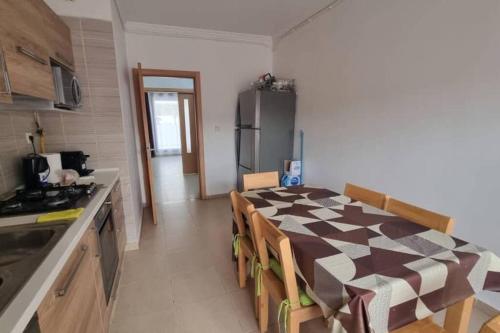 奥兰F5 -5 bedrooms Apt- Residence Hasnaoui avec parking Oran Algeria的一间带桌子的厨房和一间带冰箱的厨房