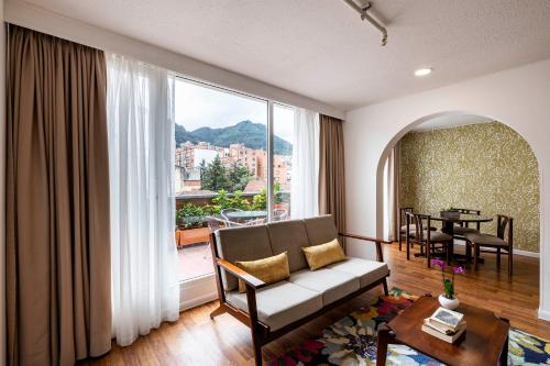 波哥大Hotel Vilar América的带沙发和大窗户的客厅