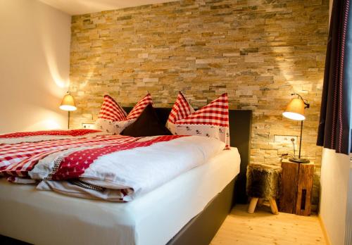 绍滕斯Ferienhaus Ötztal-Lodge的一间卧室配有红色和白色枕头的床