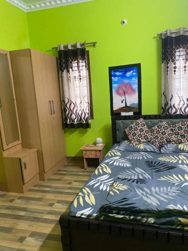 班加罗尔Ghar-fully furnished house with 2 Bedroom hall and kitchen的一间卧室设有一张床和绿色的墙壁