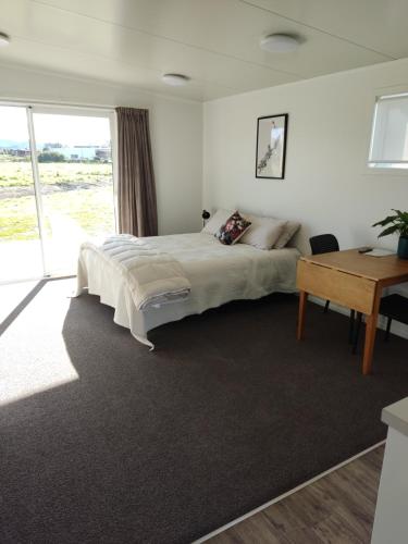 WairoaThe Ferry Hotel的一间卧室配有一张大床和一张书桌