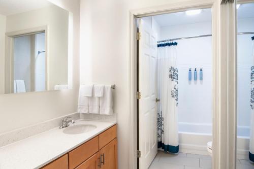 厄兰格辛辛那提机场原住客栈的白色的浴室设有水槽和淋浴。
