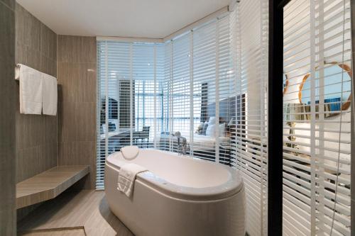 曼谷素坤逸S31酒店的带浴缸的浴室和大窗户