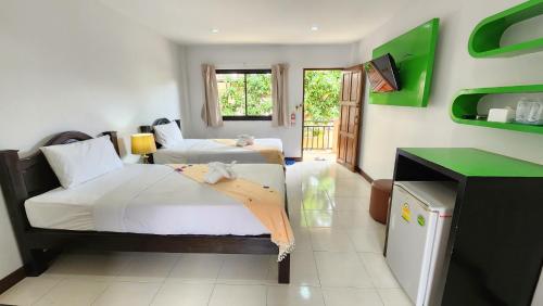 查汶潘旁酒店的一间卧室配有两张床和电视。