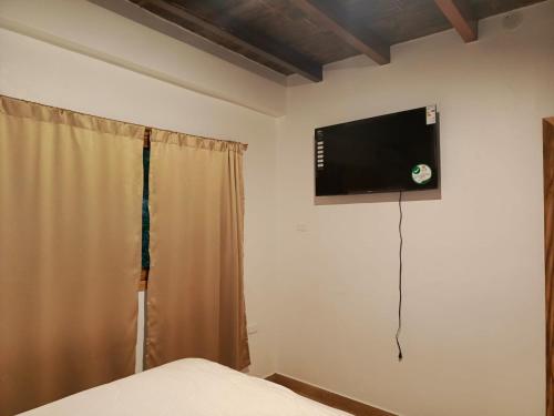 洛佩斯港Casa Happy Beach Ayampe的卧室配有壁挂式平面电视。