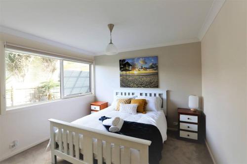 日落大道Sunderland Escape的卧室配有白色的床和窗户。