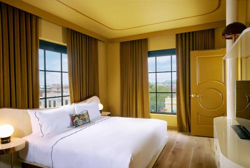 路易斯威尔Hotel Genevieve的卧室设有白色大床和窗户。