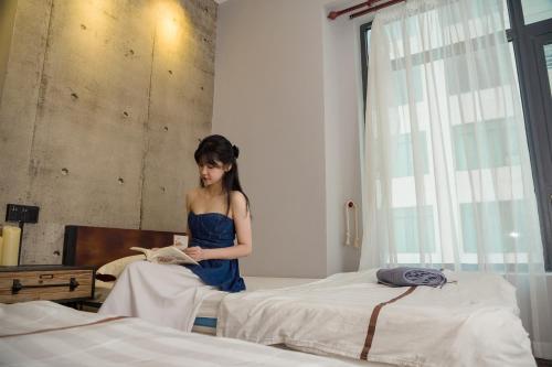 芽庄Oceanus Oasis Retreat Muong Thanh Vien Trieu的站在卧室读书的女人