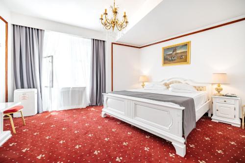 锡比乌一帕特洛酒店的卧室配有白色的床和红色地毯