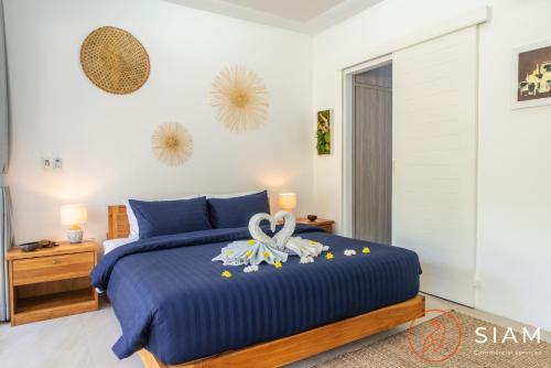 苏梅岛Villa Sumalee 3Br Private Pool的一间卧室配有一张蓝色的床,上面有毛巾