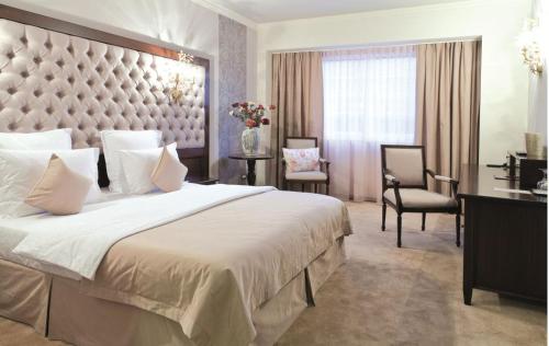 拉姆尼库沃尔恰Simfonia Boutique Hotel的一间卧室配有一张大床和大床头板