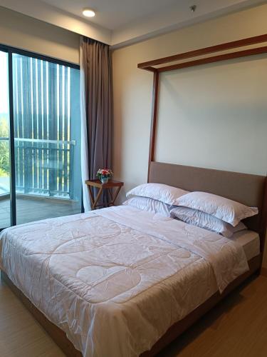 关丹Timurbay Seafront Residence Mawar Inap Homestay的一间卧室设有一张大床和大窗户
