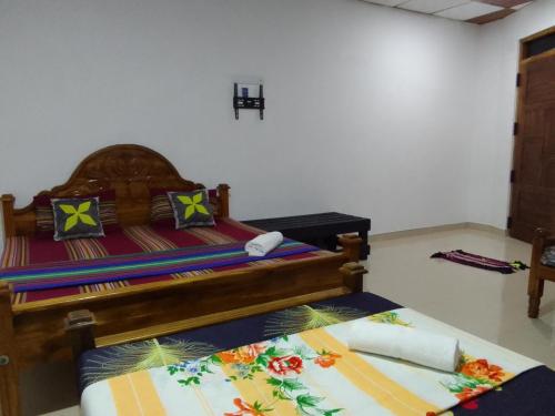 NochchiyagamaWilpattu buma的一间卧室配有一张带色彩缤纷枕头的木床。