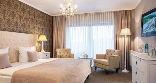 伯森艾科豪森维克多的魏因加特纳博斯塔尔酒店的一间卧室配有一张床、一把椅子和电视