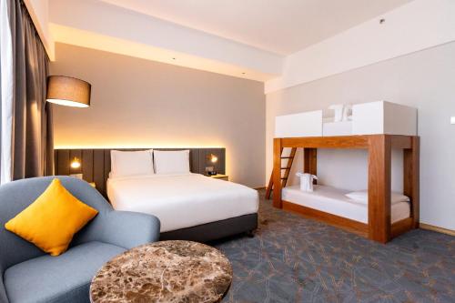 雪邦Holiday Inn Sepang - Airport的配有一张床和一把椅子的酒店客房