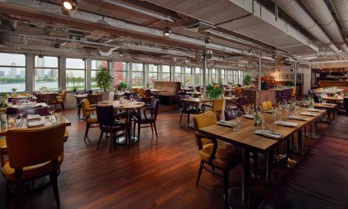 鹿特丹SS鹿特丹酒店与餐厅的餐厅设有木桌、椅子和窗户。