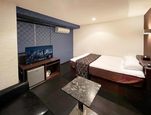 东京Ikebukuro Grand Hotel的配有一张床和一台平面电视的酒店客房